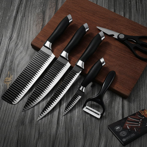Set of knives and a pair of scissors on a wooden cutting board with a card in the background.